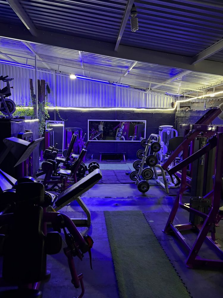 Sala de GYM GOKI de noche, con iluminación LED violeta sobre las máquinas